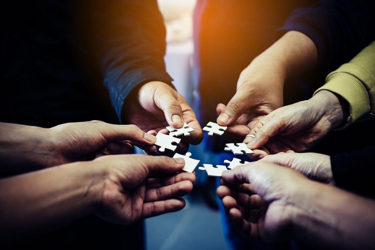 group putting puzzle pieces in circle